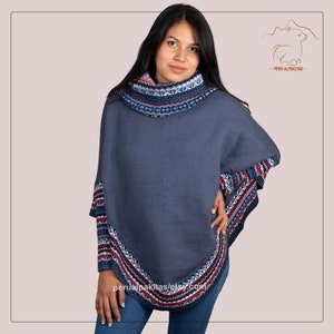 Könnte beinhalten: Ein blaues Alpakawollponcho mit einem farbenfrohen geometrischen Muster am Ausschnitt und Saum. Das Poncho hat einen hohen Kragen und ist in Peru hergestellt.