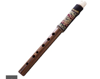 Puede incluir: Una flauta de madera con una tela de color marrón y negro con estampado que cubre la parte superior. La flauta tiene seis agujeros y una boquilla blanca.