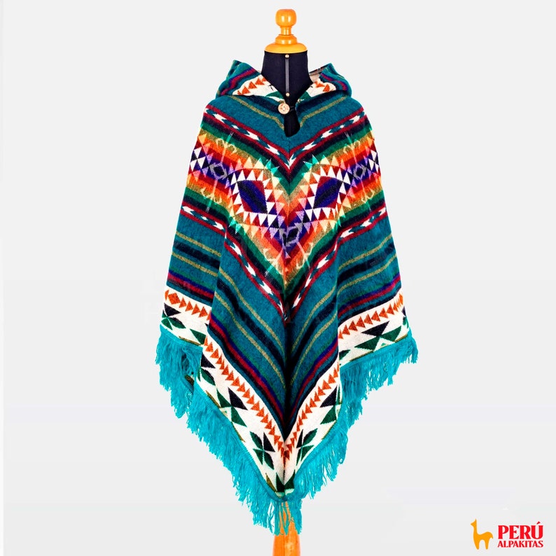May include: A turquoise blue hooded poncho with a colorful geometric pattern. The poncho has fringe around the edges and a button closure at the neck.