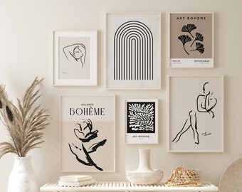 May include: A white wooden bench with two white wicker baskets underneath. There are five black and white framed prints on the wall behind the bench. The prints feature abstract designs, a flower, and a woman.
