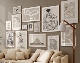 May include: A beige sectional sofa with multiple cushions in a living room featuring a gallery wall of black and white abstract art prints, a wooden floor, and a wooden floor lamp.