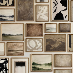 K&ouml;nnte beinhalten: Eine Sammlung gerahmter Kunstwerke mit goldenen Rahmen. Die Kunstwerke zeigen abstrakte Designs und Landschaftsbilder in neutralen T&ouml;nen von Beige, Braun und Gr&uuml;n. Die Anordnung erzeugt eine Galerie-Wand-&Auml;sthetik.