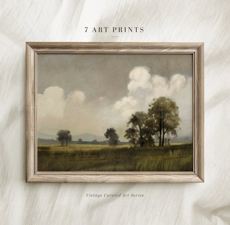 Op de afbeelding: Een ingelijst vintage landschapsschilderij dat een veld met bomen en wolken op de achtergrond toont. Het schilderij is in een lichtbruin houten lijst. De tekst "7 ART PRINTS" staat boven de lijst en de tekst "Vintage Curated Art Series" staat onder de lijst.