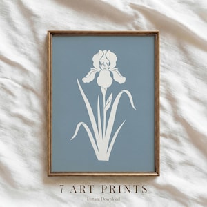 May include: A framed art print featuring a white iris flower illustration on a muted blue background. The artwork is enclosed in a wooden frame. The text "7 ART PRINTS" and "Instant Download" are at the bottom of the print.