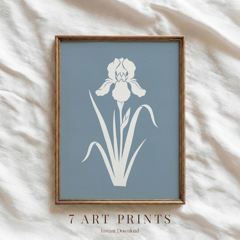 May include: A framed art print featuring a white iris flower illustration on a muted blue background. The artwork is enclosed in a wooden frame. The text "7 ART PRINTS" and "Instant Download" are at the bottom of the print.