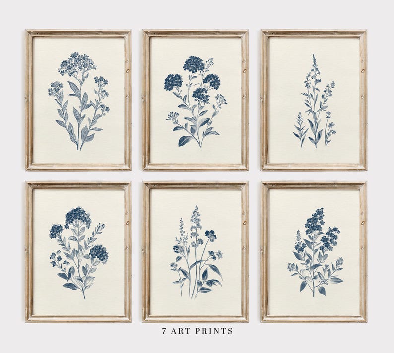 May include: Set of seven framed art prints featuring botanical illustrations in shades of blue. Each print showcases a different floral arrangement against a cream-colored background. The frames are made of light-colored wood. The text "7 ART PRINTS" is at the bottom.