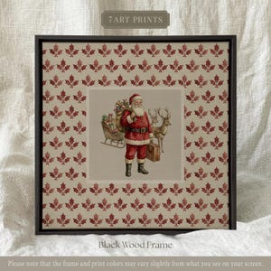 Könnte beinhalten: Ein quadratischer Kunstdruck in einem schwarzen Holzrahmen mit einem sich wiederholenden Muster aus roten Stechpalmenblättern auf beigem Grund. Die Mitte zeigt eine Vintage-Illustration des Weihnachtsmanns mit Schlitten, Rentier und Koffer.