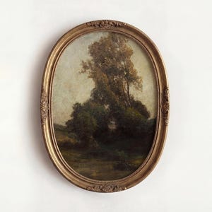 May include: An oval-shaped framed painting featuring a landscape scene with trees and foliage. The artwork is set within a gold-colored ornate frame. The painting depicts a natural scene with a muted color palette.