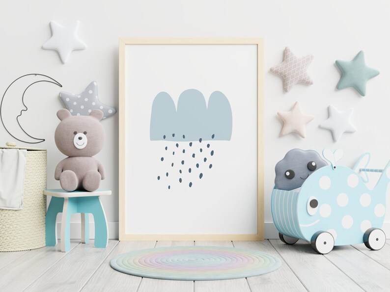 May include: A framed print featuring a blue cloud with rain drops, displayed in a child's room. The room is decorated with star-shaped wall hangings, a teddy bear, a whale-shaped toy, and a round rug.