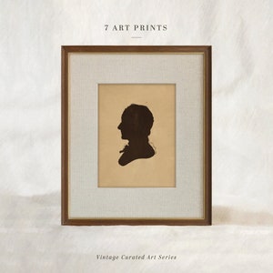 May include: A framed art print featuring a dark silhouette of a person in profile. The print is set against a tan background with a white mat and a brown wooden frame. The text "7 ART PRINTS" and "Vintage Curated Art Series" are visible.