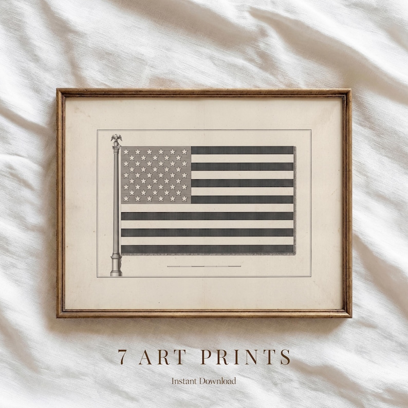 May include: Framed art print featuring a vintage illustration of the American flag. The flag is depicted in black and white with stars and stripes, mounted on a cream-colored background. The print is in a gold-toned frame. Text at the bottom reads "7 ART PRINTS" and "Instant Download."