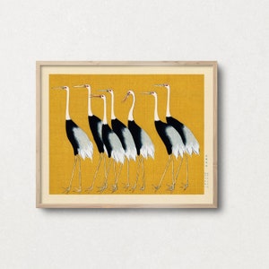 Puede incluir: Una impresión enmarcada de una obra de arte japonesa que representa siete grullas blancas y negras caminando en línea sobre un fondo amarillo.