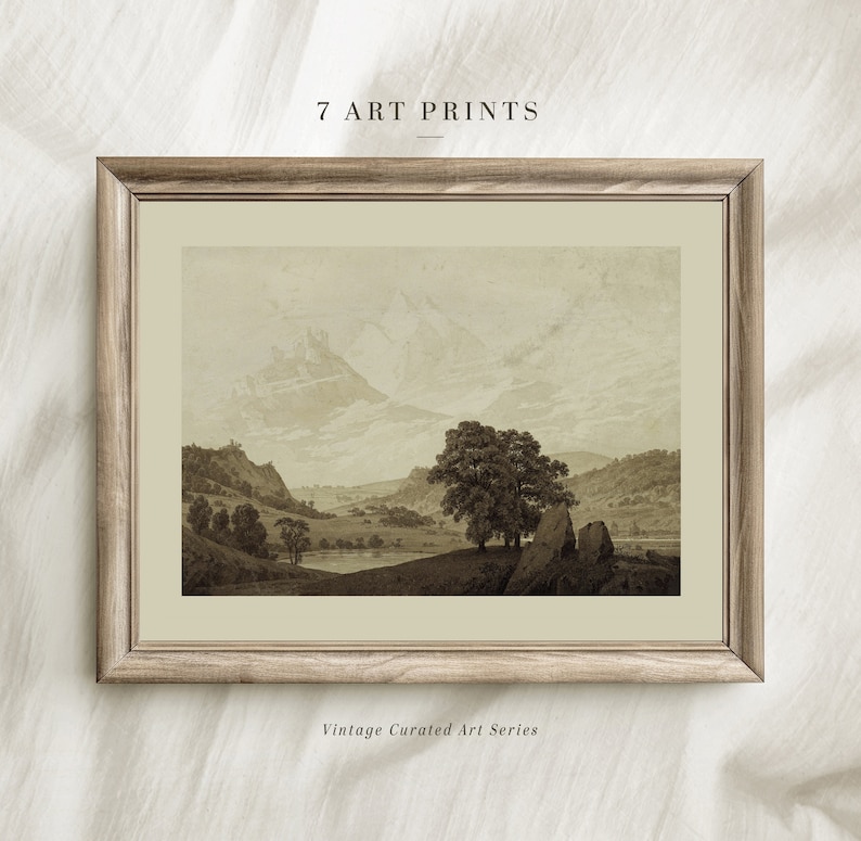 Op de afbeelding: Een ingelijste sepia-getinte landschapsdruk van een bergketen met een meer op de voorgrond. De print is in een lichtbruin houten lijst met een witte passe-partout. De tekst "7 ART PRINTS" staat boven de lijst en "Vintage Curated Art Series" staat onder de lijst.