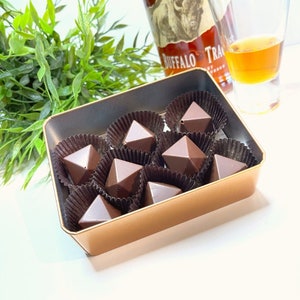 Faceted bourbon chocolate bonbons filled with a traditional bourbon ball filling made with pecans, buffalo trace bourbon, ginger spices, butter and powder sugar.