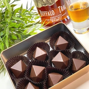 Faceted bourbon chocolate bonbons filled with a traditional bourbon ball filling made with pecans, buffalo trace bourbon, ginger spices, butter and powder sugar.