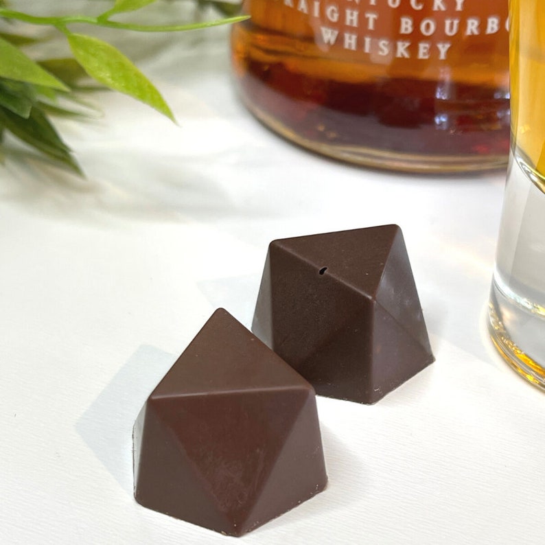 close up image of Faceted bourbon chocolate bonbons filled with a traditional bourbon ball filling made with pecans, buffalo trace bourbon, ginger spices, butter and powder sugar.