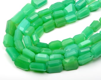 Könnte beinhalten: Stränge aus facettierten, hellgrünen Edelsteinperlen. Die Perlen sind rechteckig mit mehreren Facetten, wodurch ein funkelnder Effekt entsteht. Die Perlen sind zu einer Halskette oder einem Armband aufgereiht.