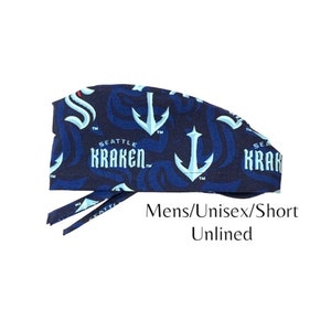 May include: A blue and white patterned surgical scrub hat with the Seattle Kraken logo. The hat is unlined and has a short tie.
