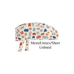 May include: White short unlined scrub cap with a colorful pattern of abstract breasts. The text "Mens/Unisex/Short Unlined" is printed on the cap.