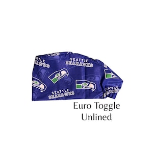 May include: A blue and green patterned scrub hat with the Seattle Seahawks logo. The hat is labeled "Euro Toggle Unlined".