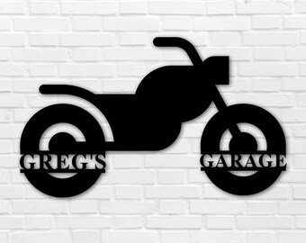 May include: Black metal motorcycle silhouette with the words "Greg's Garage" on the wheels.