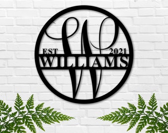 May include: Black metal circle with the letters "W" and "W" in a script font. The letters are intersected by a horizontal bar with the text "EST 2021 WILLIAMS" on it.
