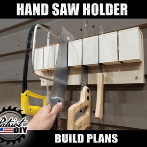 May include: A wooden hand saw holder with five slots for storing saws. The holder is mounted on a wall and has a light wood finish. The text "HAND SAW HOLDER" is at the top of the image and the text "BUILD PLANS" is at the bottom of the image.