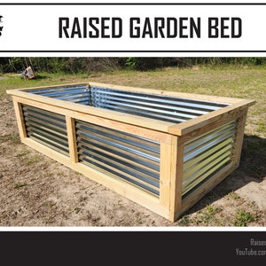 May include: A rectangular raised garden bed with a corrugated metal interior and a wooden frame. The frame is made of light-colored wood. The text "RAISED GARDEN BED" is displayed at the top of the image.