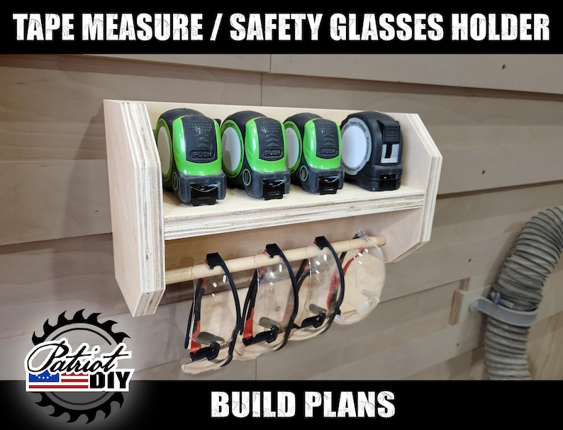 May include: A wooden wall-mounted organiser with a shelf for holding tape measures and a dowel rod for hanging safety glasses. The organiser is made of plywood and has a light wood finish. The tape measures are green and black, and the safety glasses are clear.