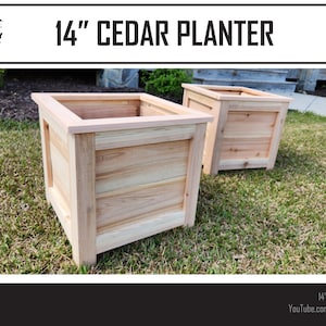 Puede incluir: Dos jardineras de madera de cedro de 14 pulgadas, una delante de la otra, sobre un c&eacute;sped verde. Las jardineras est&aacute;n hechas de madera de cedro natural de color marr&oacute;n claro. El texto "14" CEDAR PLANTER" es visible en la parte superior de la imagen.