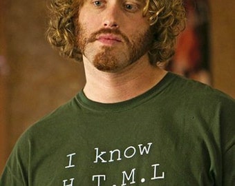 May include: A man with curly blond hair and a beard is wearing a green t-shirt with the text "I know H.T.M.L. (How to Meet Ladies)"
