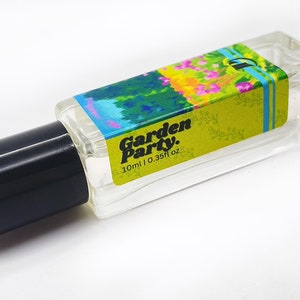May include: A clear glass bottle with a black cap and a colorful label that says "Garden Party." The label has a green background with a floral design and the text "30ml | 0.33fl oz."