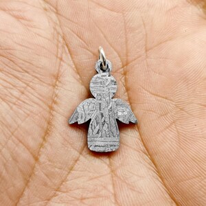May include: A silver angel charm pendant with intricate details. The charm is in the shape of an angel with wings and a halo. The charm is made of metal and has a shiny finish.