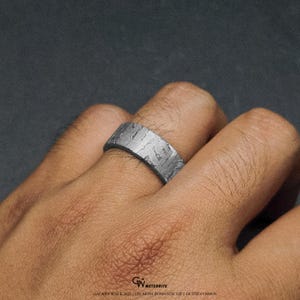 May include: A silver ring with a textured surface, worn on a finger. The ring has a band design and appears to be made of a metallic material. The text at the bottom reads "GALAXY WALK 2023: THE MOST ROMANTIC GIFT OF THE COSMOS."
