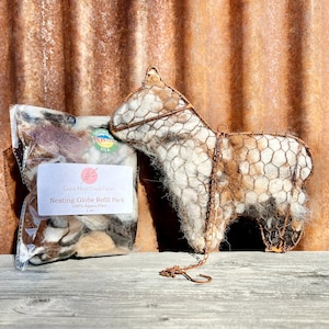 May include: A brown and white alpaca fiber refill pack for a nesting globe. The pack is labeled "Crazy Head Creek Farms Nesting Globe Refill Pack 100% Alpaca Fiber 1 oz."