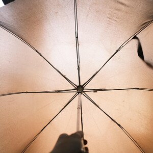 Puede incluir: Una taza de cer&aacute;mica blanca con un asa negra y el texto "But First, Coffee" en negrita negra. La taza est&aacute; sobre un fondo borroso. La taza mide aproximadamente 10 cm de altura.