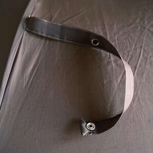 Puede incluir: Una taza de cer&aacute;mica blanca con asa negra y el texto "But First, Coffee" en negrita negra. La taza se encuentra sobre un fondo borroso, sugiriendo un ambiente acogedor.