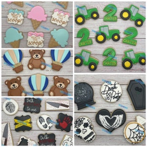 May include: Assortment of decorated sugar cookies with various themes, including ice cream, hot air balloons, teddy bears, tractors, numbers, skulls, hearts, and coffins.  The cookies are decorated with colorful icing and sprinkles.