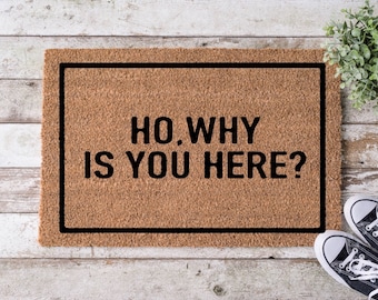 May include: A brown coir doormat with black trim and the text "Ho, why is you here?" printed on it.