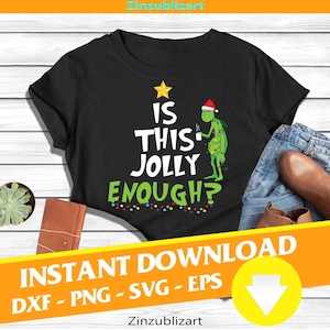 May include: Black t-shirt with the text "IS THIS JOLLY ENOUGH?" in white and green. The design includes a Grinch character wearing a Santa hat and holding a cup. A yellow star and string of lights complete the design.
