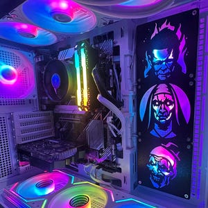 Peut inclure: Un boîtier d'ordinateur personnalisé avec un éclairage RVB vibrant. Le boîtier présente un panneau noir avec des portraits illuminés de personnages de films d'horreur. Les composants internes comprennent des ventilateurs, une carte graphique et des barrettes de RAM.