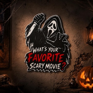 Könnte beinhalten: Ein Wandschild mit der Figur Ghostface in einer schwarzen Kapuzenrobe, die ein Messer hält, mit dem Text "WHAT'S YOUR FAVORITE SCARY MOVIE?" in weißer und roter Schrift. Das Schild hat einen schwarzen Hintergrund mit weißem Rand.