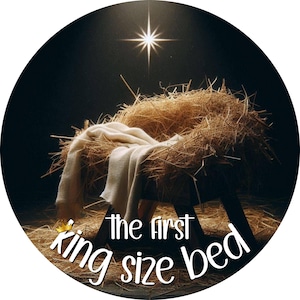 May include: Circular image featuring a manger made of straw, with a white blanket draped over it. The text "the first king size bed" is written in a whimsical font. A bright star shines above the manger, set against a dark background.