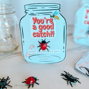 Puede incluir: Una tarjeta de San Valentín azul y blanca con forma de frasco con una mariquita roja y el texto "You're a good catch!!"  ¡Feliz Día de San Valentín! Tu amigo, Lincoln.