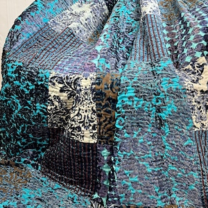 May include: A patchwork quilt made of velvet fabric in shades of teal, brown, and grey. The quilt has a variety of patterns, including paisley, stripes, and geometric designs.