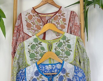 Può includere: Quattro diverse camicie con stampa floreale appese a grucce di legno. Le camicie sono in tonalità di rosso, verde, blu e giallo. Ogni camicia ha un diverso motivo floreale ed è realizzata in un tessuto leggero.