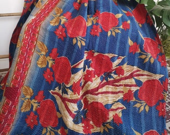 May include: A blue and red kantha quilt with a floral pattern. The quilt is made of cotton and is hand-stitched. It is a traditional Indian textile.