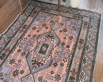 May include: A pink and purple patterned rug with a black and white geometric design. The rug has a fringe border.