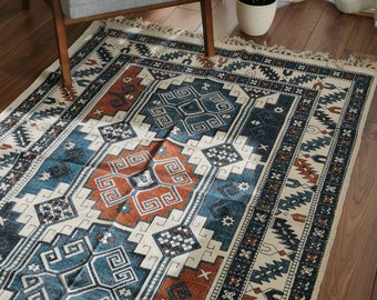 May include: A blue and orange patterned rug with a geometric design. The rug has a fringed border and is laid out on a wooden floor.