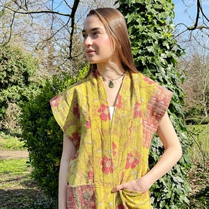 May include: A yellow and red floral print quilted vest with a  sleeveless design and two pockets. The vest is made of a soft, lightweight fabric and has a relaxed fit.